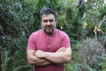 Portrait of caucasian male gardener with crossed hands looking at camera at garden centre. specialist working at bonsai plant nursery, independent horticulture business. — Stock Photo