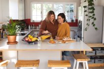 Lesbisches Paar lächelt und bereitet in der Küche das Frühstück zu. häuslicher Lebensstil, Freizeit zu Hause verbringen. — Stockfoto