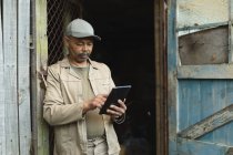 African american male gardener using tablet at garden centre. specialist working at bonsai plant nursery, independent horticulture business. — Stock Photo