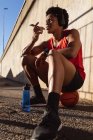 Жирний афроамериканець, який займається спортом у місті, користується смартфоном на вулиці. Фітнес і активне вуличне життя. — стокове фото