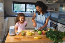 Felice razza mista madre e figlia che cucinano insieme in cucina. stile di vita domestico e trascorrere del tempo di qualità a casa. — Foto stock