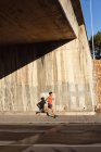 Convient à l'homme afro-américain qui fait de l'exercice dans la ville en courant dans la rue. forme physique et mode de vie urbain actif. — Photo de stock