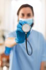 Portrait of caucasian female doctor wearing face mask and holding stethoscope. medical and healthcare services during coronavirus covid 19 pandemic. — Stock Photo