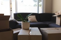 Куча коробок, подготовленных перед переездом дома рядом с диваном. бытовой образ жизни, свободное время дома. — стоковое фото