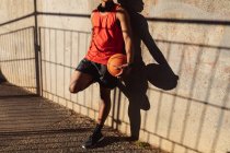 Ajuste o homem americano africano que exercita na cidade que prende o basquete na rua. fitness e estilo de vida urbano ativo ao ar livre. — Fotografia de Stock