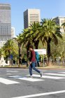 Afroamerikaner in der Stadt mit Smartphone und zu Fuß. digitaler Nomade unterwegs, unterwegs in der Stadt. — Stockfoto