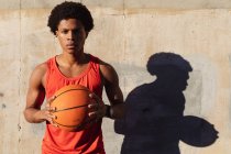 Портрет афроамериканського чоловіка, який займається спортом у місті, утримуючи баскетбол на вулиці. Фітнес і активне вуличне життя. — стокове фото