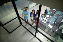 Diversos colegas de negócios masculinos e femininos lendo notas coloridas na parede de vidro. trabalhando em negócios em um escritório moderno. — Fotografia de Stock