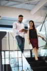 Diverse männliche und weibliche Kollegen nutzen Tablets und sprechen. Arbeit in einem modernen Büro. — Stockfoto