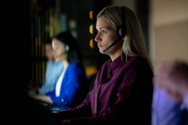 Caucasian businesswoman working at night wearing headset. working late in business at a modern office. — Stock Photo