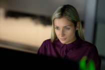 Femme d'affaires caucasienne travaillant la nuit en utilisant un ordinateur portable. travailler tard dans les affaires dans un bureau moderne. — Photo de stock
