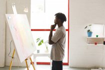 Африканський американський чоловічий художник на роботі, що займається мистецтвом в художній студії. Творіння та натхнення у художній майстерні. — стокове фото
