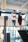 Diversos colegas de negocios masculinos y femeninos usando tableta y hablando. trabajar en un negocio en una oficina moderna. - foto de stock