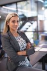 Ritratto di donna d'affari caucasica sorridente seduta sul tavolo e che guarda la macchina fotografica. lavorare in azienda in un ufficio moderno. — Foto stock