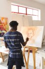 Peintre afro-américain au travail portrait de peinture sur toile dans un atelier d'art. création et inspiration dans un atelier de peinture d'artistes. — Photo de stock