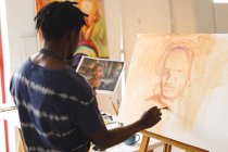 Peintre afro-américain au travail portrait de peinture sur toile dans un atelier d'art. création et inspiration dans un atelier de peinture d'artistes. — Photo de stock