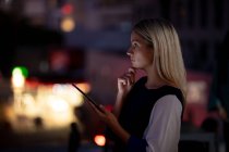 Caucasian businesswoman working at night using smartphone. working late in business at a modern office. — Stock Photo
