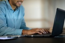 Empresário de raça mista trabalhando à noite usando laptop. trabalhando até tarde em negócios em um escritório moderno. — Fotografia de Stock