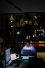 Африканський американський бізнесмен працює вночі, сидячи за столом і використовуючи ноутбук. Працював у сфері бізнесу в сучасному офісі.. — стокове фото