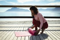 Mulher de raça mista praticando ioga no dia ensolarado à beira-mar. estilo de vida saudável, desfrutando de tempo de lazer ao ar livre. — Fotografia de Stock