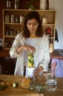 Mixed race woman preparing healthy drink in kitchen. healthy lifestyle, enjoying leisure time at home. — Stock Photo