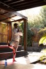 Homem caucasiano vestindo roupas esportivas e praticando ioga no tapete de ioga. passar o tempo fora em casa. — Fotografia de Stock