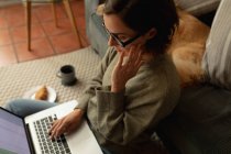 Kaukasische Frau mit Hund im Wohnzimmer, auf dem Boden sitzend, mit Laptop arbeitend. häuslicher Lebensstil, Freizeit zu Hause genießen. — Stockfoto