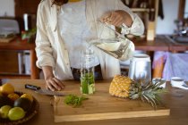 Mujer preparando bebida saludable en la cocina. estilo de vida saludable, disfrutando del tiempo libre en casa. - foto de stock