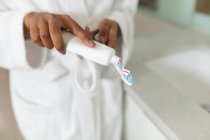 Mujer en el baño sosteniendo pasta de dientes y cepillo de dientes. estilo de vida doméstico, disfrutando del tiempo libre de autocuidado en casa. - foto de stock