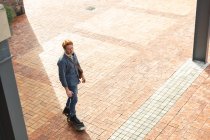 Serious caucasian male business creative arriving on skateboard outside workplace. independent creative business people working at a modern office. — Stock Photo