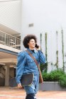 Sorridente afroamericano business femminile creativo utilizzando smartphone e tenendo skateboard. uomini d'affari creativi indipendenti che lavorano in un ufficio moderno. — Foto stock