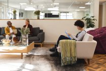 Diverse männliche und weibliche Kollegen arbeiten im Lounge-Bereich zusammen. Arbeit im kreativen Geschäft in einem modernen Büro. — Stockfoto