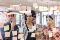 Diverse männliche und weibliche Kollegen arbeiten zusammen, Brainstorming, schreiben an Notizen. Arbeit im kreativen Geschäft in einem modernen Büro. — Stockfoto