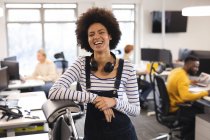 Portrait of smiling mixed race female creative at work, looking to camera. working in creative business at a modern office. — Stock Photo