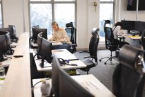 Diverse colleghe al lavoro, sedute alle scrivanie, a prendere appunti. lavorare in attività creative in un ufficio moderno. — Foto stock