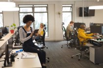 Разнообразные коллеги-мужчины и женщины за работой, сидя за партами, используя компьютеры. работа в творческом бизнесе в современном офисе. — стоковое фото