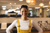 Portrait of smiling mixed race female creative looking to camera. working in creative business at a modern office. — Stock Photo