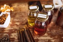 Vista ravvicinata di più ingredienti su un tavolo di legno per la produzione di gin in distilleria. produzione di alcol e concetto di filtrazione. — Foto stock