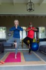 Feliz pareja mayor diversa en ropa de ejercicio practicando yoga juntos, meditando. estilo de vida saludable y activo de jubilación en el hogar. - foto de stock