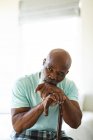 Ragionevole anziano afroamericano in camera da letto con in mano un bastone da passeggio. stile di vita di pensione, trascorrere del tempo a casa. — Foto stock