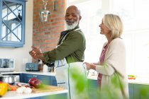 Glückliches älteres Ehepaar in Kochschürze beim gemeinsamen Kochen. gesunder, aktiver Lebensstil im Ruhestand zu Hause. — Stockfoto