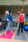 Casal diverso sênior feliz em roupas de exercício praticando ioga juntos, alongamento. estilo de vida saudável e ativo em casa. — Fotografia de Stock