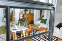 Счастливый американец-альбинос с дредами, работающий из дома и делающий подкаст. удаленная работа с использованием технологии на дому. — стоковое фото