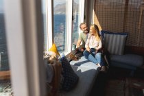 Glückliches kaukasisches reifes Paar, das im Wohnzimmer Kaffee trinkt. Freizeit zu Hause genießen. — Stockfoto