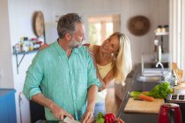 Feliz casal maduro caucasiano cozinhar juntos na cozinha moderna. desfrutar de tempo de lazer em casa. — Fotografia de Stock