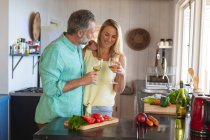Happy caucasian mature couple cooking together in the modern kitchen. enjoying leisure time at home. — Stock Photo