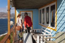 Glückliches kaukasisches reifes Paar mit Koffern, die ins Hotelzimmer kommen. Freizeit, Reisen und Urlaub. — Stockfoto
