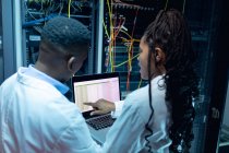 Tecnici informatici afroamericani che usano laptop che lavorano nella sala server. tecnologia digitale di memorizzazione delle informazioni e rete di comunicazione. — Foto stock
