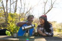 Casal diverso bebendo café e fazendo uma pausa de caminhadas no campo. saudável, estilo de vida ao ar livre ativo e tempo de lazer. — Fotografia de Stock