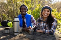 Разнообразная пара пьет кофе и отдыхает от походов в сельской местности. здоровый, активный уличный образ жизни и досуг. — стоковое фото